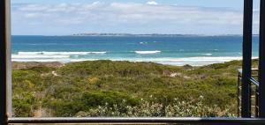a view of the ocean from a window at Beachfront 3-bedroom with Robben Island views in Cape Town