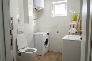 biała łazienka z toaletą i umywalką w obiekcie Apartman Sistov w mieście Kaštela
