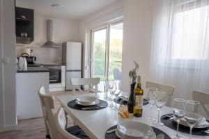 a kitchen and dining room with a table with wine glasses at Apartman Sistov in Kaštela