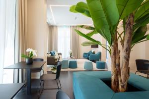 a living room with a blue couch and a tree at Vi Suites in Viareggio