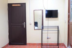 a door with a mirror and a television on a wall at Hotel Puri Lembang near Universitas Sulawesi Barat Majene in Lutan