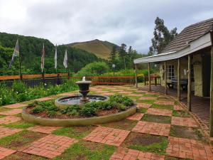 a garden with a fountain in the middle of a yard at Gooderson Leisure Mountain View Cottages Self Catering and Timeshare Resort in Drakensberg Garden