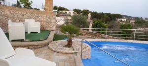 un patio con sillas blancas y una piscina en Villa Ipanema, en Salve