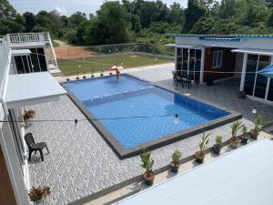einen Blick über den Pool auf ein Haus in der Unterkunft Meraga Cinta Kijal in Kijal
