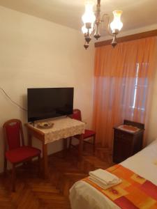 Cette chambre comprend un bureau avec une télévision et deux chaises. dans l'établissement Opium Old City Apartment, à Split