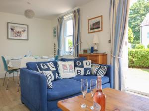a blue couch in a living room with a table at 5 Combehaven in Salcombe