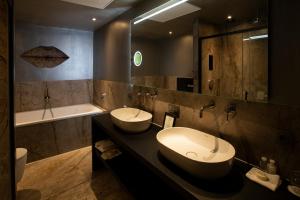 a bathroom with two sinks and a tub and a bath tub at Landhuishotel De Bloemenbeek in De Lutte +47 photos