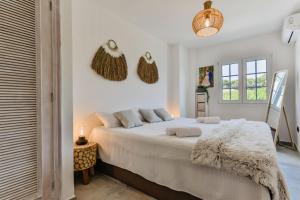 a white bedroom with a large bed with white sheets at Luxury Apartment Seaside Bay in Moraira