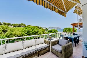 a balcony with a couch and chairs and a table at Luxury Apartment Seaside Bay in Moraira