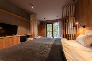 a bedroom with a large bed with a flat screen tv at Hotel Nomad in Bjelašnica