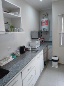 cocina con armarios blancos y encimera en cel2245508464 Céntrico en 