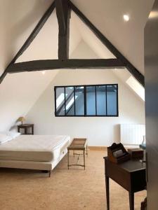 1 dormitorio en el ático con 1 cama y 1 mesa en La Michellière à Continvoir, en Continvoir