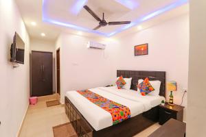a bedroom with a bed and a ceiling fan at FabExpress Elite Inn in Patna