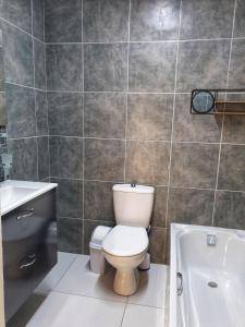 łazienka z toaletą, umywalką i wanną w obiekcie Gooderson Leisure Mountain View Cottages Self Catering and Timeshare Resort w mieście Drakensberg Garden