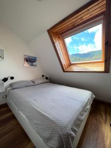 a bedroom with a bed and a large window at La Vita in Ravascletto