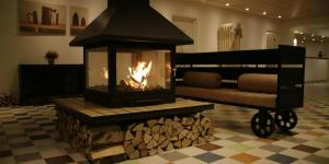 a fireplace in the middle of a room with a couch at The White Alleys Holiday Park in Voronovo