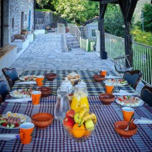 a picnic table with plates of food and fruit on it at Dembelija Rooms in Virpazar