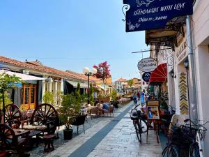 a street with tables and chairs and people walking down the street at Js House Shkoder 2 in Shkodër