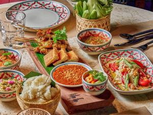 曼谷美居曼谷素坤逸酒店的桌子上摆满了各种食物的碗