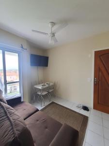 a living room with a couch and a table at Apto de frente ao mar Itanhaém in Itanhaém