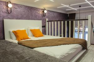 a bedroom with a large bed with orange pillows at E-lite& Meatador in Astana