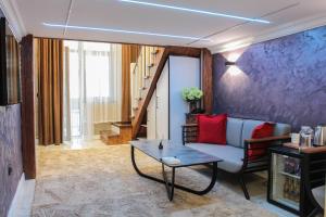 a living room with a couch and a table at E-lite& Meatador in Astana