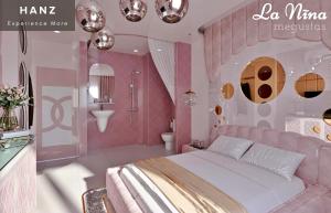 a pink bedroom with a bed and a bathroom at HANZ MeGusta Hotel Ben Thanh in Ho Chi Minh City