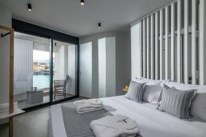 ein Schlafzimmer mit einem großen weißen Bett mit Handtüchern darauf in der Unterkunft Sea Front Salty Sea Suites Estate in Agios Nikolaos