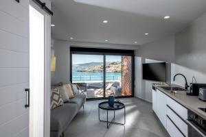 ein Wohnzimmer mit einem Sofa und Meerblick in der Unterkunft Sea Front Salty Sea Suites Estate in Agios Nikolaos