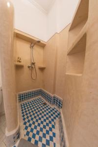 a bathroom with a shower and a checkered floor at RIAD DAR C in Marrakesh