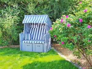 GrambinにあるFerienhaus Grambin VORP 2621の花の隣の芝生に座る青い椅子
