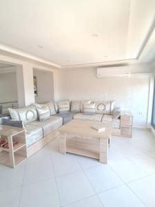a living room with a couch and a coffee table at Appartement Sable blanc in Al Hoceïma