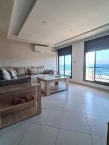 a living room with a couch and a table at Appartement Sable blanc in Al Hoceïma