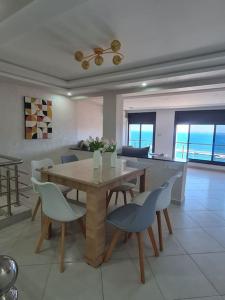 a dining room with a table and chairs and the ocean at Appartement Sable blanc in Al Hoceïma