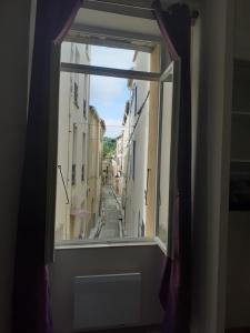 uma janela aberta com vista para uma rua da cidade em La Re'Belle em Céret