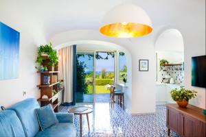 un soggiorno con divano blu e tavolo di OraBlu Exclusive Villas a Ischia