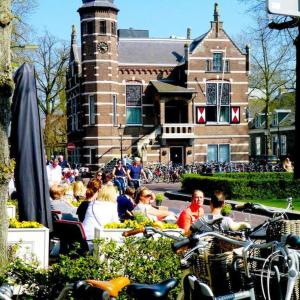 un groupe de personnes assises devant un bâtiment dans l'établissement Natuurhuisje Oisterwijk, à Oisterwijk
