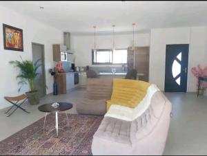 ein Wohnzimmer mit einem Sofa und einem Tisch sowie eine Küche in der Unterkunft Villa au soleil in Trans-en-Provence