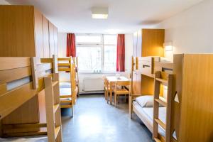 Dormitorio con letti a castello e tavolo di Jugendherberge Hamburg Horner Rennbahn ad Amburgo