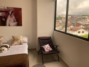 a room with a bed and a chair and a window at Hermoso Apartamento Ibagué 402 F1 in Ibagué