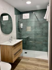 a bathroom with a sink and a glass shower at Apartamento Valbuena in Potes