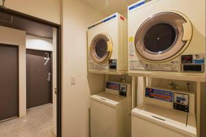 a laundry room with a dryer and a washing machine at Mash Cafe & Bed NAGANO in Nagano