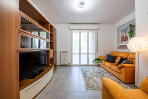 a living room with a couch and a television at Homiday - New House - Pisa Aeroporto - Free Parking in Pisa