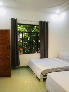 1 dormitorio con 2 camas y ventana en Quang Ngai Hostel, en Quảng Ngãi