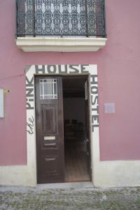 un bâtiment rose avec une porte et un balcon dans l'établissement The Pink House, à Faja Grande