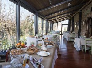 un gran comedor con mesas y sillas y comida en Albergo Le Case, en Macerata