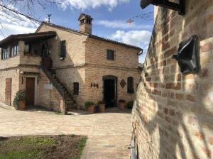 ein Gebäude mit einer Ziegelwand und einem TV darauf in der Unterkunft Albergo Le Case in Macerata