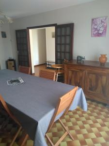 una sala da pranzo con tavolo e sedie in una stanza di Grande Maison de plain pied avec jardin arboré. a Champignelles