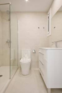 ein weißes Bad mit einem WC und einer Dusche in der Unterkunft Alcam Stadium Les Corts in Barcelona