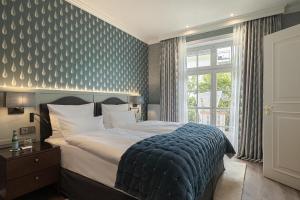 - une chambre avec un lit aux motifs bleus dans l'établissement Hotel Stadt Hamburg, à Westerland